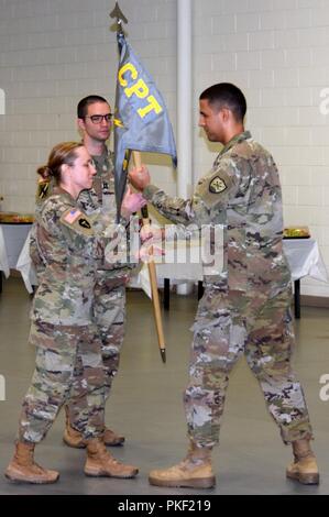 Major George Allen transfers the guidon of the Georgia Army National Guard’s 170th Cyber Protection Team to Lt. Col. Catherine Cherry, commander of the 78th Troop Support Battalion signifying his relinquishing of command while the incoming commander of the 170th CPT, Capt. Michael Mallon, observes. Stock Photo