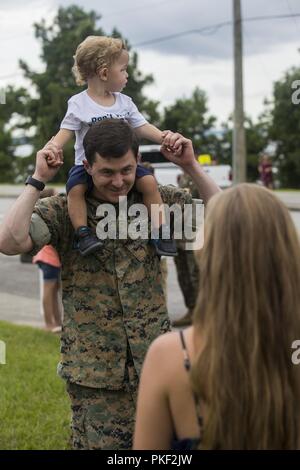 U.S. Navy Hospital Corpsman 2nd Class Brandon Mageary, with Combat Logistics Battalion 26, 2nd Marine Logistics Group, carries his son on Camp Lejeune, N.C., Aug. 5, 2018. CLB-26 supported the 26th Marine Expeditionary Unit, which returned home from a six-month deployment at sea to the U.S. Central, African and European Command areas of operation. Stock Photo