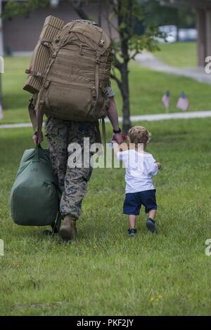 U.S. Navy Hospital Corpsman 2nd Class Brandon Mageary, with Combat Logistics Battalion 26, 2nd Marine Logistics Group, walks with his son on Camp Lejeune, N.C., Aug. 5, 2018. CLB-26 supported the 26th Marine Expeditionary Unit, which returned home from a six-month deployment at sea to the U.S. Central, African and European Command areas of operation. Stock Photo