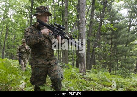 U.S. Marine Corps Sgt. Jordan Hensley a squad leader with Kilo Company, 3rd Battalion, 25th Marine Regiment, participates in a land navigation course at Exercise Northern Strike in Camp Grayling, Mich., Aug. 6, 2018. Camp Grayling, the largest National Guard center in the country covering 147,000 acres, offers many large artillery, mortar, tank ranges and maneuver courses. Stock Photo