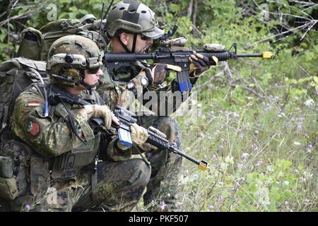 Infantry Marines with the 1st Battalion, 24th Marine Division from Grand Rapids, Mich., worked as opposing forces during simulated defense procedures and ambushes against Joint Terminal Attack Controllers from the German Army and Air Force teamed with soldiers from the 1-296th Infantry Battalion, Puerto Rico National Guard, at the Carmeuse Calcite Quarry, Rogers City, Mich., Aug. 7, 2018, during Northern Strike 18.    Northern Strike 18 is a National Guard Bureau-sponsored exercise uniting service members from many states, multiple service branches and a number of coalition countries during th Stock Photo