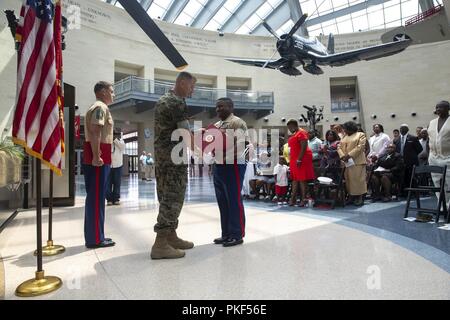 U.S. Marine Corps Lt. Col. Joel Schmidt, operations officer, Marine Corps Tactics and Operations Group, presents the meritorious service medal to Master Sgt. Marcus Gold, battalion operations chief, SEC BN, at the National Museum of the Marine Corps, Triangle, Va., July 27, 2018. Gold served 20 years of honorable and faithful military service. Stock Photo
