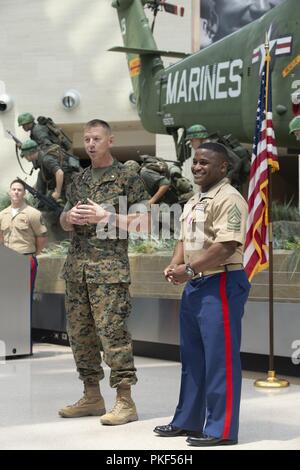 U.S. Marine Corps Lt. Col. Joel Schmidt, left, operations officer, speaks during a retirement ceremony for Master Sgt. Marcus Gold, right, battalion operations chief, SEC BN, at the National Museum of the Marine Corps, Triangle, Va., July 27, 2018. Gold served 20 years of honorable and faithful military service. Stock Photo