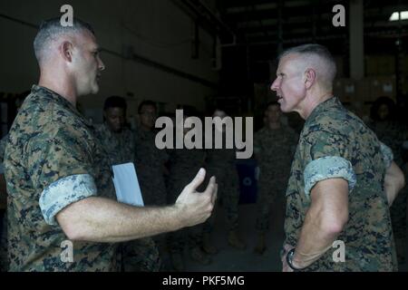 Lt. Gen. Eric Smith (right), III Marine Expeditionary Force commanding general, speaks to Lt. Col. Christopher Johnson (left), the commanding officer of Combat Logistics Battalion 31, during the III MEF general’s visit to the 31st MEU at Camp Hansen, Okinawa, Japan, Aug. 8, 2018. Smith visited the 31st MEU command post to meet Marines and Sailors before an upcoming patrol. The 31st MEU, the Marine Corps’ only continuously forward-deployed MEU, provides a flexible force ready to perform a wide-range of military operations across the Indo-Pacific region. Stock Photo