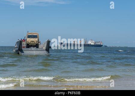 VIRGINIA BEACH, Va. (July 26, 2018) A U.S. Army vehicle approaches the bow ramp of an Assault Craft Unit (ACU) 2 Landing Craft, Mechanized (LCM) 8 in preparation to drive to shore during the Trident Sun 18 exercise. Trident Sun 18 is a maritime prepositioning force (MPF) operation intended to provide training to reserve component personnel with regards to the in stream offload of military vehicles and equipment. Stock Photo