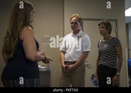 The Honorable Mr. Thomas B. Modly, undersecretary of the Navy, Department of the Navy, and his wife Robyn Modly are briefed by Tonjia Berger-Day, family readiness coordinator, Wounded Warrior Battalion-West (WWBn-W), at WWBn-W, Marine Corps Base Camp Pendleton, California, Aug. 8, 2018.  Modly was briefed on the mission of WWBn-W and how their recovery and support process help service members. Stock Photo