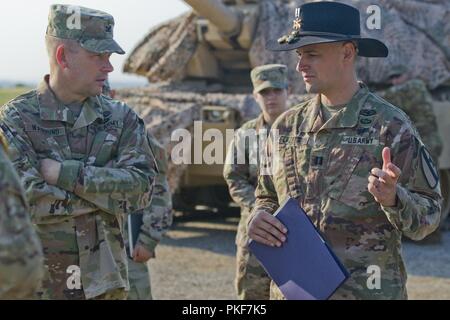 U.S. Army Capt. Patrick R. Glazebrook, the commander of Comanche Troop, 1st Squadron, 7th Cavalry Regiment, 1st Armored Brigade Combat Team, 1st Cavalry Division, and U.S. Army Col. Todd R. Wasmund, Deputy Commanding Officer (Support) for the 1st Infantry Division, discuss plans for a unit training observation day at the central training area in Várpalota, Hungary, Aug. 3, 2018. Comanche Troop invited the U.S. Ambassador to Hungary David B. Cornstein, mayors from the towns surrounding the training area, Hungarian soldiers and local Hungarian media to view static displays and demonstrations of  Stock Photo