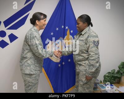 Col. Debra A. Lovette, 81st Training Wing commander, coins Tech. Sgt. Toni Justice, Detachment 2, 336th Training Squadron NCOIC Commander’s Support Staff, during her visit to the Air Force detachment at Fort Meade, Maryland, July 25, 2018. The detachment falls under the 81st TRW. Stock Photo