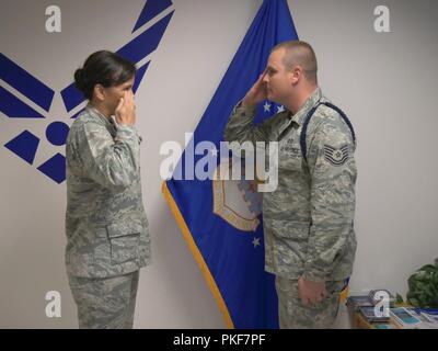 Col. Debra A. Lovette, 81st Training Wing commander, returns a salute from Tech. Sgt. Dustin Record, Detachment 2, 336th Training Squadron Military Training Flight chief, after coining him during her visit to the Air Force detachment at Fort Meade, Md., July 25, 2018. The detachment falls under the 81st TRW. Stock Photo
