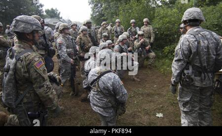 U.S. Army Reserve Soldiers from the 302nd Military Police Company listen to a briefing about hand and arm signals before starting their patrol during Lethal Warrior Training at Fort McCoy, Wisconsin, on Aug. 8, 2018. Stock Photo