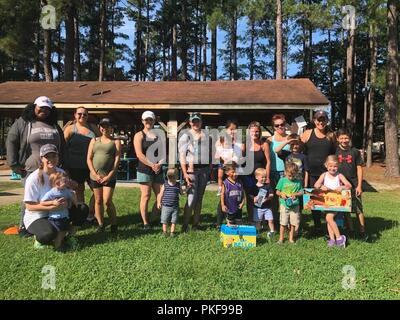 Spouses and children of paratroopers assigned to 5th Squadron, 73rd Cavalry Regiment, 3rd Brigade Combat Team, 82nd Airborne Division pose for a photo during the inaugural Airborne Thunder at Pope Army Airfield’s Woodland Park on Aug. 8, 2018. Spouses gathered for the fitness event to build their relationships while exercising and celebrating the coming school season. Stock Photo