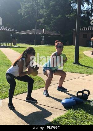 Two spouses of paratroopers assigned to the 5th Squadron, 73rd Cavalry Regiment, 3rd Brigade Combat Team, 82nd Airborne Division perform kettlebell squats during the inaugural Airborne Thunder at Pope Army Airfield’s Woodland Park on Aug. 8, 2018. The event was designed to build relationships within the Squadron’s Family Readiness Group and inform spouses of upcoming training events. Stock Photo