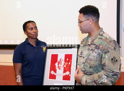 Master Sgt. David Foster presented Sgt. Maj. Rhonda Byrd of the U.S. Sergeants Major Academy with framed U.S. Army Corps of Engineers North Atlantic Division colors for serving as guest speaker for U.S. Army Garrison Fort Hamilton's Women's Equality Day observance at the at the base's Community Club on August 9, 2018. Stock Photo