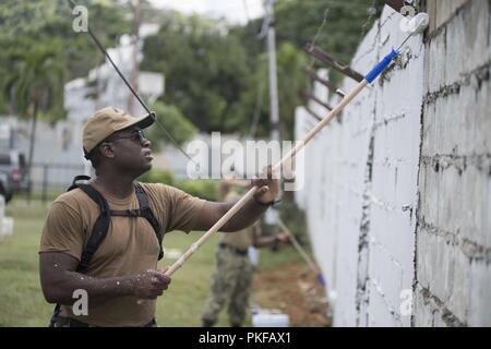 PORT OF SPAIN, Trinidad and Tobago (Aug. 10, 2018) Religious Programs Specialist 1st Class Robert Moody, a Sailor stationed on the Whidbey Island-Class Dock Landing Ship USS Gunston Hall (LSD 44), paints a wall during a community relation event at a military cemetery in Port of Spain, Trinidad and Tobago. The ship is on deployment supporting Southern Seas, which is an annual collaborative deployment in the U.S. Southern Command area of responsibility where a task group will deploy to conduct a variety of exercises and multinational exchanges to enhance interoperability, increase regional stabi Stock Photo