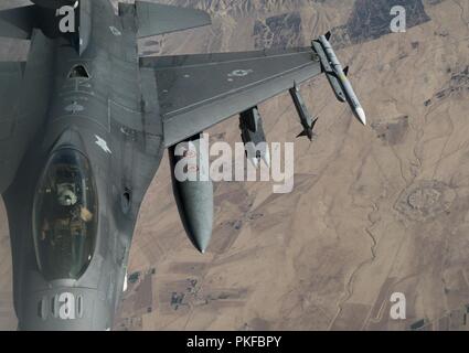 An F-16 Fighting Falcon over Iraq prepares to maneuver away after receiving fuel from a KC-135 Stratotanker Aug.11, 2018. The F-16 Fighting Falcon is a compact, multi-role fighter aircraft. It is highly maneuverable and has proven itself in air-to-air combat and air-to-surface attack. It provides a relatively low-cost, high-performance weapon system for the United States and allied nations. Stock Photo