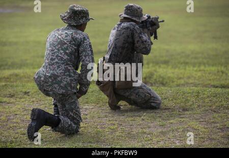 Lt. Amir with the 22nd Royal Malay Army Regiment watches Marines attached to the 2nd Battalion, 3rd Marines, Fox Company at Range 600 in Kota Belud, Malaysia, on August 11, 2018. Marines and sailors with 3rd Marine Division and the 13th Marine Expeditionary Unit will train with our allies in the Pacific for one month. Our comprehensive partnership with Malaysia is pivotal in maintaining regional security in the Indo-Pacific. Stock Photo