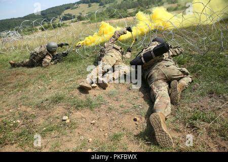 Soldiers assigned to 1st Platoon, Alpha Company, 1st Battalion, 4th Infantry Regiment, breach an obstacle as part of their squad scenario training exercise in the Hohenfels Training Area July 30, 2018, Stock Photo