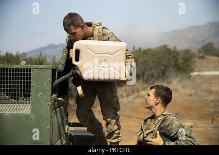 U.S. Marine Lance Cpl. Cody Brent (left) and Lance Cpl. Corey Mckenney, with 11th Communication Company, 1st Battalion, 11th Marine Regiment, 1st Marine Division, monitor and refuel a generator that powers communication antennas during SUMMER FIREX 2018 at Marine Corps Base Camp Pendleton, Calif., Aug. 8, 2018. The exercise enhanced 11th Marine Regiment’s ability to plan, coordinate and deliver lethal fire support, counter fires and regimental command and control. Stock Photo