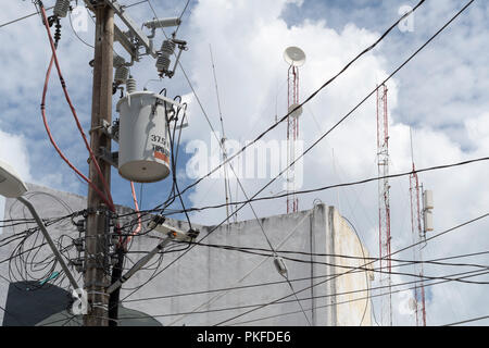 Street electric cables on a pole with satellite dishes and radio antennas Stock Photo