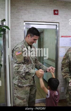 DONGDUCHEON, Republic of Korea – 2nd Lt. Seth Maddy, a 6th Battalion, 37th Field Artillery Regiment fires officer and Cadet Troop Leadership Training sponsor from Gilbert, Arizona plays with a student at a local orphanage July 31st. Maddy and Cadet Michael Bertlesman, a Rochester Institute of Technology rising senior political science major from Plainview, New York, attended a birthday party with Soldiers of the 210th Field Artillery Brigade. Stock Photo