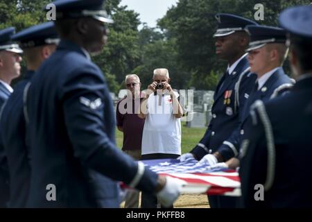 Family members, friends and fellow Airmen attend a full honors funeral service for Chief Master Sgt. Charles Palmer who was laid to rest at Arlington National Cemetery, Va., July 27, 2018. Palmer, age 80, passed away at home with his family by his side Dec. 21, 2017. More than 100 family members, friends and SAM Fox Airmen attended the internment to pay their respects. Palmer served in the Air Force for 31 years. He spent 13 of those years serving as a flight attendant on board Air Force One and eleven years as Chief Flight Steward until his retirement in 1986. Palmer served Presidents Richard Stock Photo