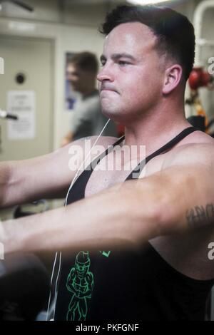 PACIFIC OCEAN - U. S. Marine Sgt. Timothy McGinniss, a Fire Supportman with the Command Element, 13th Marine Expeditionary Unit (MEU), works out at the gym during a regularly scheduled deployment of the Essex Amphibious Ready Group (ARG) and the 13th MEU, July 26, 2018. The Essex ARG/MEU team is a strong, flexible, responsive and consistent force capable of maneuver warfare across all domains; it is equipped and scalable to respond to any crisis from humanitarian assistance and disaster relief to contingency operations. (U. S. Marine Corps Stock Photo