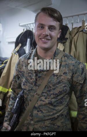 PACIFIC OCEAN – U.S. Marine Lance Cpl. Jake MacGregor, a squad leader with India Company, Battalion Landing Team 3/1, 13th Marine Expeditionary Unit (MEU), poses for a photo aboard the Wasp-Class Amphibious assault ship USS Essex (LHD 2) during a regularly scheduled deployment of the Essex Amphibious Ready Group (ARG) and the 13th MEU, July 30, 2018. The Essex ARG/MEU team is a strong, flexible, responsive and consistent force capable of maneuver warfare across all domains; it is equipped and scalable to respond to any crisis from humanitarian assistance and disaster relief to contingency oper Stock Photo