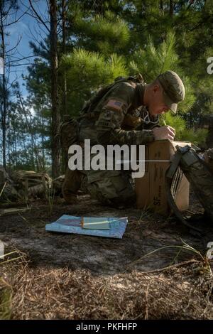 Spc. Timothy Jordan of Alpha Troop,  6th Squadron, 8th Cavalry Regiment, 2nd Armored Brigade Combat Team, writes grid coordinates for the land navigation course, August 9, at Fort Stewart, Ga. Stock Photo