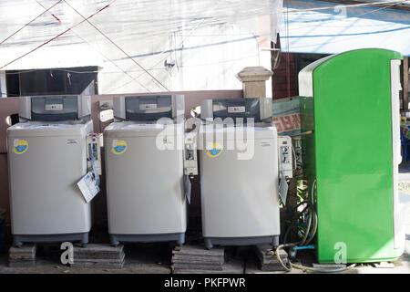 Phuket, Thailand - 25 February 2018: Public coin laundry on city street. Row of washing machines for self-service Stock Photo