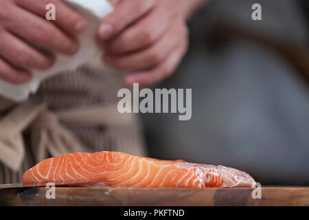Chef preparing raw fresh salmon on cutting board in Japanese sushi restaurant - fresh sea food, making sashimi Stock Photo