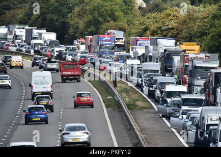Drivers stand alongside their vehicles on the M5 motorway near Taunton in Somerset after the road was closed following a collision this morning between a lorry and several cars in which two people died.
