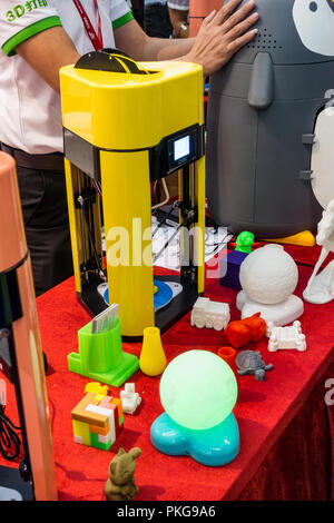 3-D printed objects and printer on table at China tech expo Stock Photo