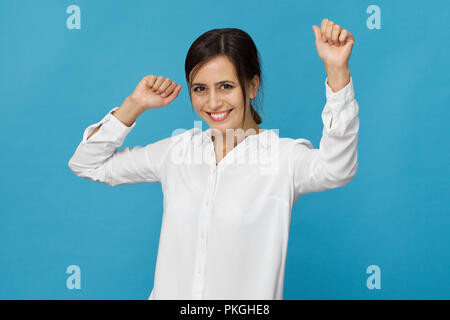 Happy young woman smiling against blue background Stock Photo