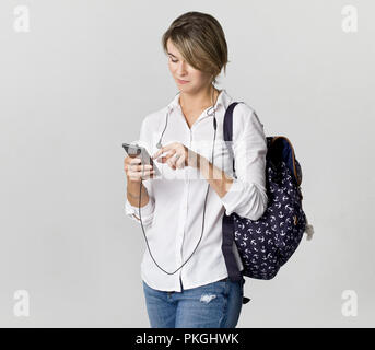 Young women in white shirt, holding smartphone, isolated Stock Photo