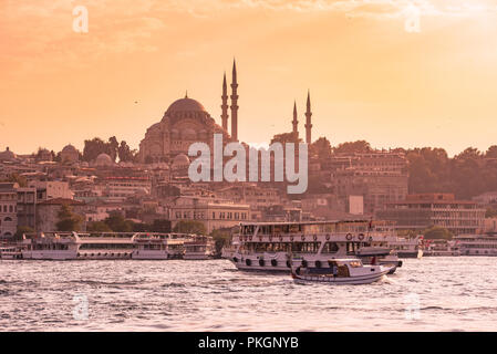 Eminonu Port with Ships and Suleymaniye Mosque in the Fatih district at Golden Horn River before sunset, Istanbul, Turkey. Travel concept and Sea fron Stock Photo