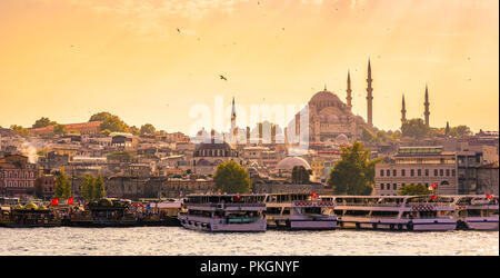 Eminonu Port with Ships and Suleymaniye Mosque in the Fatih district at Golden Horn River before sunset, Istanbul, Turkey. Travel concept and Sea fron Stock Photo