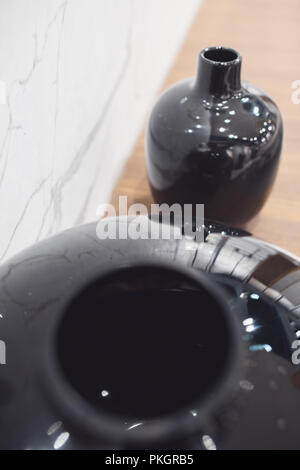 two black tall ceramic vases, decoration object on blurred floor background Stock Photo