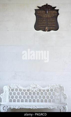 Above an iron bench is a plaque (to airmen who sacrificed themselves to save the lives of residents in Chesham and Waltham Cross) on a wall in the ame Stock Photo