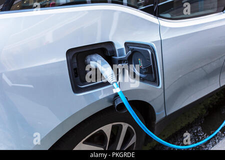 Electric car connected to a street charging point, Bothwell Street, Glasgow, UK Stock Photo