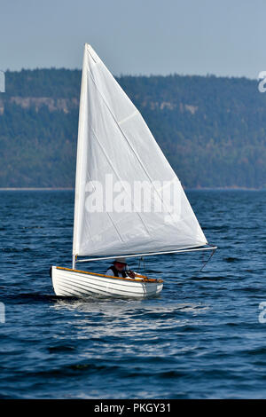A small sail boat sailing on the water in the Strait of Georgia near Vancouver Island British Columbia Canada Stock Photo