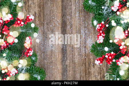 red and white christmas - twig with red berries and green evergreen tree borders on wood with copy space Stock Photo