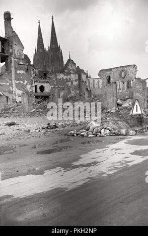 1950s, historical, Koln, Germany, a bomb site and ruined buidlings showing the damage left over after WW2. The city's famous Gothic Cathedral which was not destroyed despite the bombings, can be seen in the background. Stock Photo