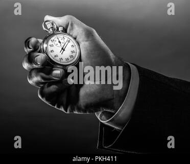 A business hand holding stop watch in black white. Stock Photo