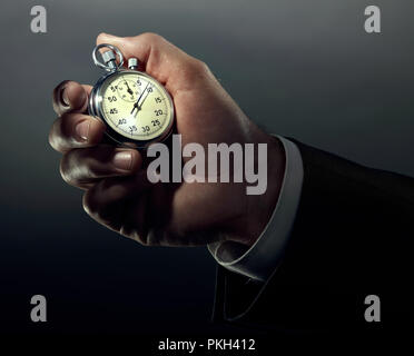 A business hand holding stop watch in color. Stock Photo
