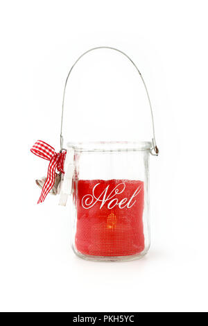 Homemade, DIY, Glass Jar Christmas Tealight candle holder with handle and Noel writing, jingle bells, red ribbon, white wooden star and bow. Lit Teali Stock Photo
