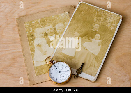 Old photographs from the early 1900s & an 18ct gold pocket watch on a light wood background, United Kingdom Stock Photo