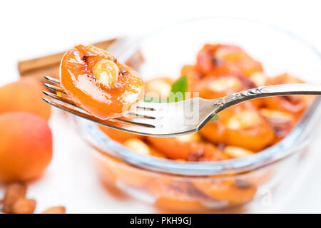 Caramelized  apricots with almonds isolated on white Stock Photo