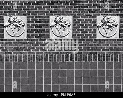 New Orleans, LA USA - May 9, 2018  -  Concrete 3 Flowers on Red Brick Wall at Tulane University B&W Stock Photo