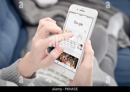 Kyiv, Ukraine - January 24, 2018: Woman using Google app on  Apple iPhone 8 plus at home. Google it is the most-used search engine on the World Wide W Stock Photo