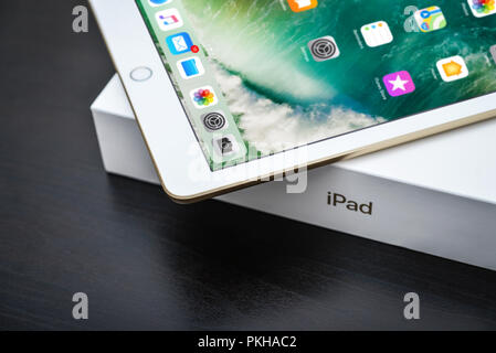 Kyiv, Ukraine - Fabruary 6, 2018: Brand new white Apple iPad Gold with box on black wooden background closeup, 7th generation of the iPad, developed b Stock Photo